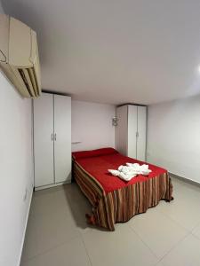 a bedroom with a red bed and white cabinets at Solares, Departamento zona centro in La Rioja