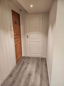 a hallway with a white door and a wooden floor at Fjordclaw SNM- adjoining the Bergen city & Nature, Free parking in Bergen