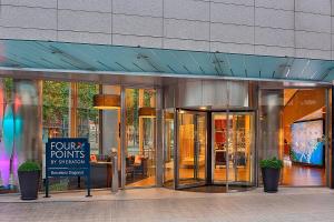 a glass building with a sign in front of it at Four Points by Sheraton Barcelona Diagonal in Barcelona