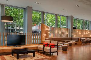 a living room with a tv and a couch and chairs at Four Points by Sheraton Barcelona Diagonal in Barcelona