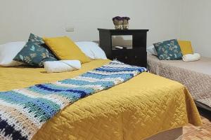 a bedroom with two beds and a yellow blanket at Joya de Santa Ana, Apartamento privado completo in Santa Ana