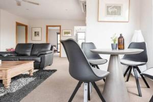 sala de estar con sofá, mesa y sillas en CBD Apartment with WiFi & Parking, en Launceston