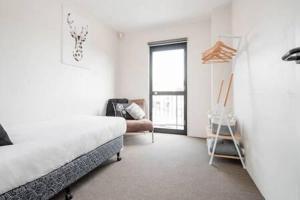 a bedroom with a bed and a chair and a window at CBD Apartment with WiFi & Parking in Launceston