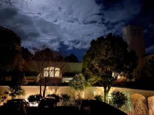 uma vista nocturna de um edifício com árvores e nuvens em B&B Retreat志摩 em Shima