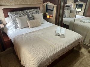 a bedroom with a large bed with slippers on it at Well Appointed American Style Park Home in Kempsey