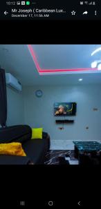 D'EXQUISITE APARTMENTS في إيبادان: غرفة معيشة مع أريكة وطاولة