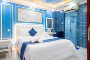 a blue bedroom with a bed and a shower at Venice Hotel in Ho Chi Minh City