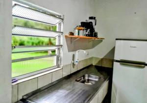 a small kitchen with a sink and a window at Casas de Campo Beija-Flor & Bem-Te-Vi, Mata Atlântica, Juquitiba, SP in Juquitiba