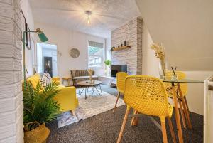 a living room with a table and yellow chairs at Comfy Contractor Stay in Stoke - Free Parking in Stoke on Trent