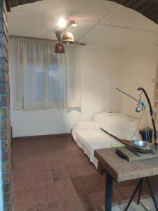 a room with a bed and a table with a lamp at Departamento para 4 personas. in Maipú
