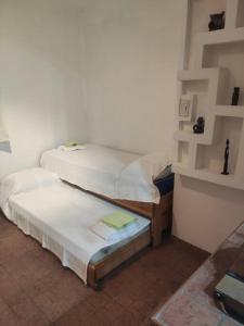 two twin beds sitting in a room with a wall at Departamento para 4 personas. in Maipú
