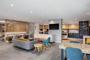 a lobby with a couch and chairs and a kitchen at TownePlace Suites by Marriott Iron Mountain in Iron Mountain