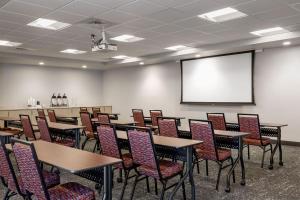 a classroom with tables and chairs and a projection screen at TownePlace Suites by Marriott Iron Mountain in Iron Mountain