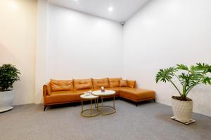 ein Wohnzimmer mit einem Sofa und einem Tisch in der Unterkunft Gems Hotel - Khách sạn Trảng Bàng in Trảng Bàng