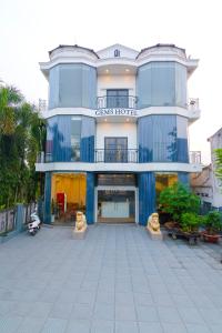 un gran edificio azul con un patio frente a él en Gems Hotel - Khách sạn Trảng Bàng, en Trảng Bàng