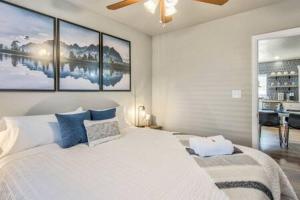 a bedroom with a large white bed with blue pillows at Vibrant Watermelon - Hot Tub, BBQ-Grill, King-Bed, Backyard, Parking in Colorado Springs