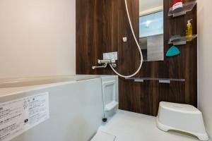 a bathroom with a white toilet and a sink at Shizuk+O Stay in Sapporo