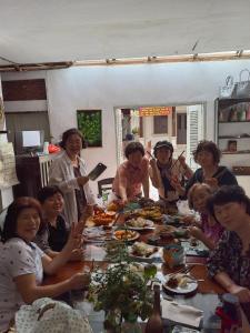 Eine Gruppe von Menschen, die an einem Tisch sitzen und essen in der Unterkunft 左岸小筑 in Luang Prabang