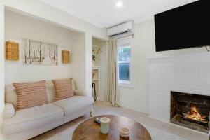 a living room with a couch and a fireplace at Charming Cottage on Croton #1 in West Palm Beach