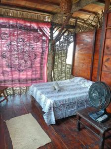 - une chambre avec un lit et une table avec un ventilateur dans l'établissement Incanto do paraiso, à Icaraí