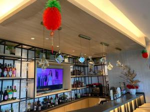 bar z telewizorem i bar z alkoholem w obiekcie AEON SUITES STAYCATION managed by ARIA HOTEL w mieście Davao
