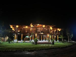 ein großes Holzhaus in der Nacht mit Lichtern in der Unterkunft Dak Nguyen Homestay & Farm 2 in Gia Nghĩa