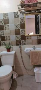 ein Badezimmer mit einem WC, einem Waschbecken und einem Spiegel in der Unterkunft Sassy's Place II in Baguio City