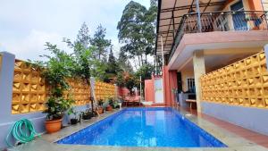 una piscina en medio de un edificio en Villa Dinar Mountain View Villa Keluarga Kapasitas 30 Orang di Lembang Dekat Dusun Bambu, en Lembang