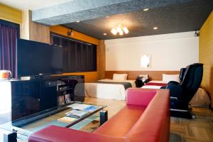 a hotel room with a television and two beds at ホテル ラヴィアン HOTEL Lavien 