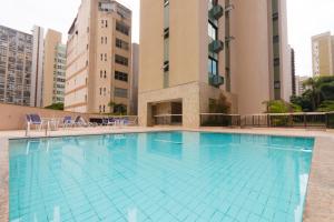 a large swimming pool in front of a building at Volpi Residence na Savassi - Sinta-se em casa! in Belo Horizonte