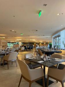 un comedor con mesas y sillas en un restaurante en Suíte Luxo São Conrado - Hotel Nacional, en Río de Janeiro