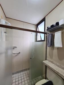 uma casa de banho com uma cabina de duche em vidro e um WC. em Volpi Residence na Savassi - Sinta-se em casa! em Belo Horizonte