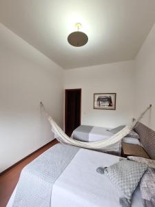 a bedroom with two beds and a hammock at Volpi Residence na Savassi - Sinta-se em casa! in Belo Horizonte