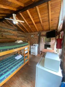 um quarto com um frigorífico e um fogão numa cabina em Cabañas de madera 25 m2 Estilo Rústico em La Granja