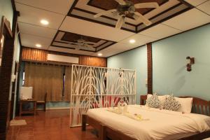 a bedroom with a bed and a ceiling fan at Koh Kood Cabana in Ban Lak Uan