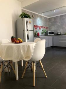 a kitchen with a white table and a refrigerator at CASA GRANDE in Mendoza