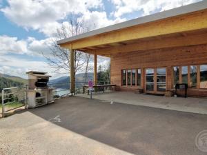 a large wooden building with a grill in front of it at Chalet authentique avec terrasse, animaux acceptés - FR-1-496-242 in Saint-Rirand