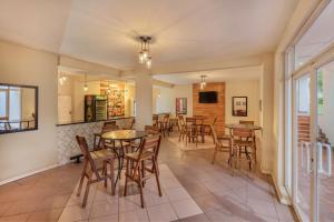 a dining room with tables and chairs and windows at Protea Hotel by Marriott Chingola in Chingola