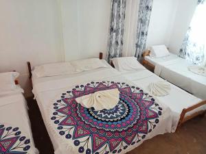 Duas camas num quarto com um cobertor colorido em Isla Haruhay em Dapa