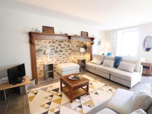 a living room with a couch and a tv at Gîte Saint-Bonnet-de-Salers, 5 pièces, 9 personnes - FR-1-742-288 in Saint-Bonnet-de-Salers