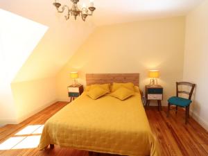 a bedroom with a bed and two lamps and a chair at Gîte Saint-Bonnet-de-Salers, 5 pièces, 9 personnes - FR-1-742-288 in Saint-Bonnet-de-Salers