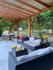 un patio con sofás y una pérgola de madera en Fabulosa casa en parcela Molco Alto, en Molco