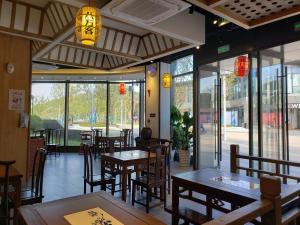 um restaurante com mesas e cadeiras de madeira e janelas em CM Service Apartment Suzhou Science Amp Technology Town em Suzhou