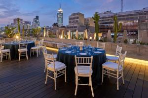a set of tables and chairs on a deck with a city skyline at City Centro by Marriott Ciudad de Mexico in Mexico City