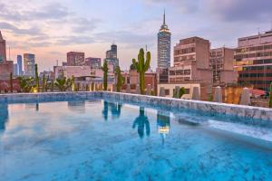 a swimming pool with a city skyline in the background at City Centro by Marriott Ciudad de Mexico in Mexico City