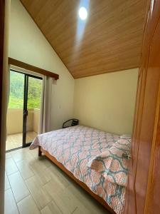 a bedroom with a bed and a large window at Casa Colibrí in Bijagua +7 photos
