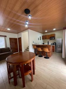 a living room with a table and a kitchen at Casa Colibrí in Bijagua
