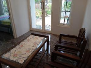 Habitación con mesa, silla y ventanas. en Siroen Homestay en Banyuwangi