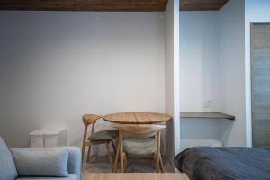 een kamer met een tafel, 2 stoelen en een bed bij ASCEND【2min from Asahikawa sta】 in Asahikawa