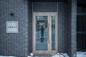 een reflectie in een glazen deur op een gebouw bij ASCEND【2min from Asahikawa sta】 in Asahikawa